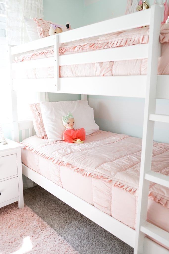 Big girls bedroom update with bunk beds, pink bedding by Beddy's Beds, chandeliers, gold and aqua accents.