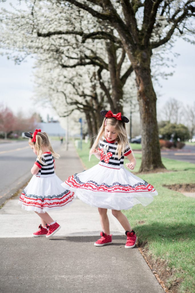 Little girls in minnie mouse dresses on sidewalk 