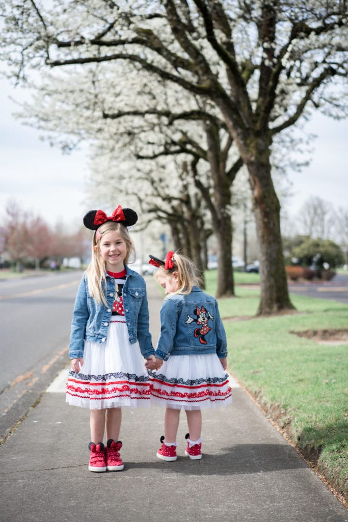 Little girls in minnie mouse dresses on sidewalk 