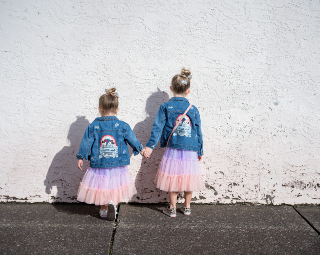 two girls in colorful dresses with jean jackets