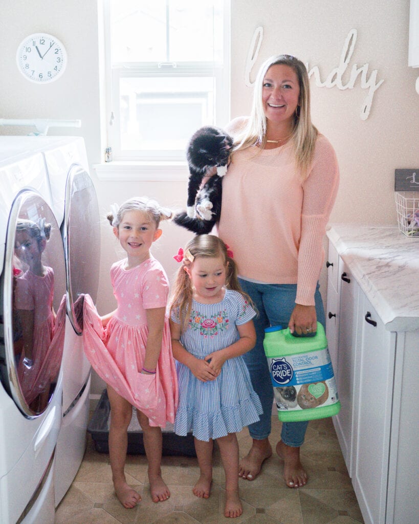Mom and daughters with cat in laundry room